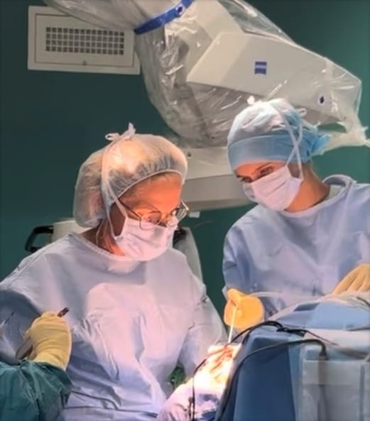 Le Pr Emery et son assistante sous le microscope opératoire